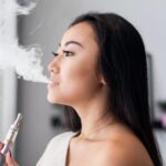 casual-asian-woman-vaping-electronic-cigarette-at-home-e1626834065238.jpeg
